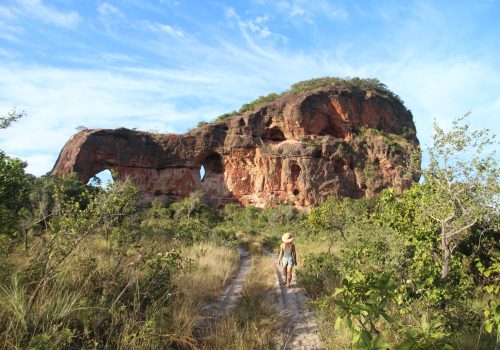 Mulher nao identificada caminhando próximo ao arco do sol, em aurora do Tocantins, Serras gerais
